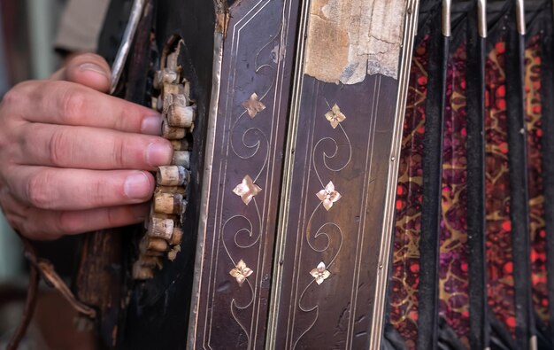 Detail der Hand eines Argentiniers, der Tango auf einem Akkordeon in La Boca Buenos Aires Argentinien spielt Selektiver Fokus