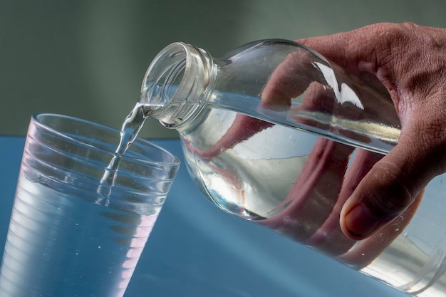 Foto detail der person, die ein glas wasserhydratationskonzept füllt