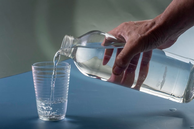 Detail der Person, die ein Glas Wasserhydratationskonzept füllt