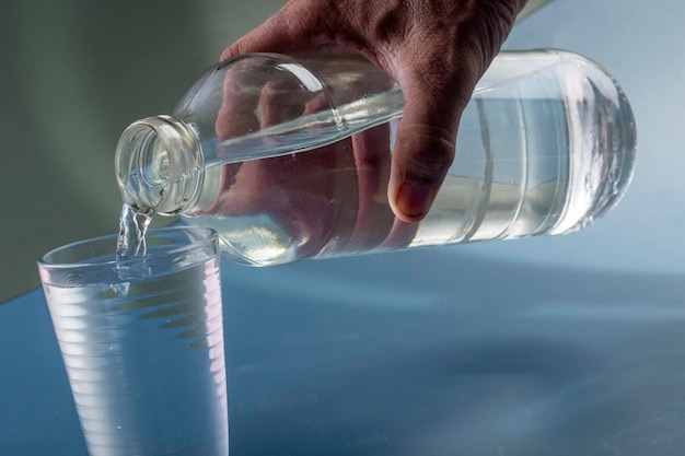 Detail der Person, die ein Glas Wasserhydratationskonzept füllt