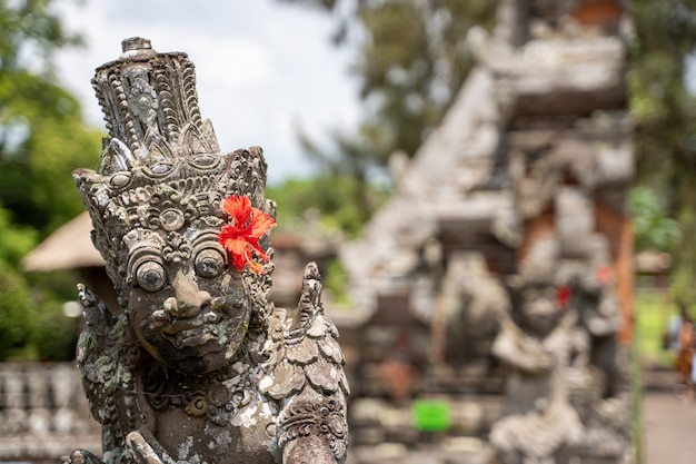 Detail der Spitze einer Steinstatue in einem Hindu-Tempel mit einer roten Blume