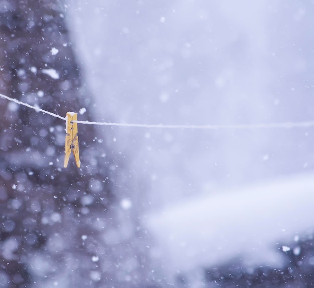 Detail der Winternatur auf dem Land Wäscheklammer an einem Seil im Freien auf Schneefallhintergrund