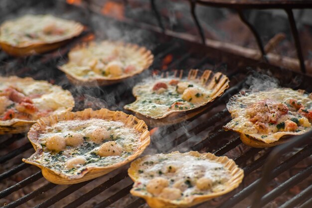 Detail des Kochens auf dem Grill von Jakobsmuscheln mit Rauch