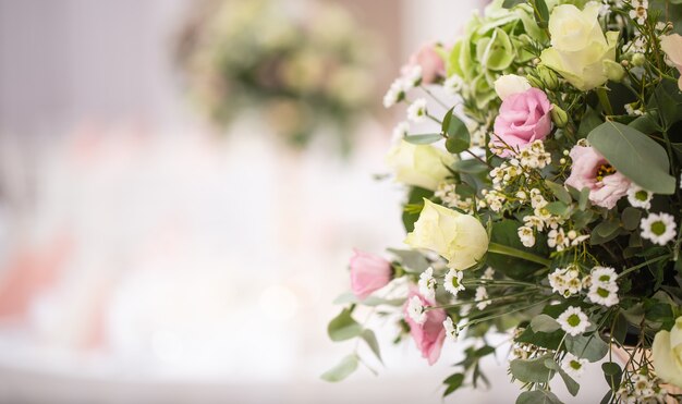 Detail eines Hochzeitsblumenstraußes mit rosa Rosen auf der rechten Seite des Bildes.