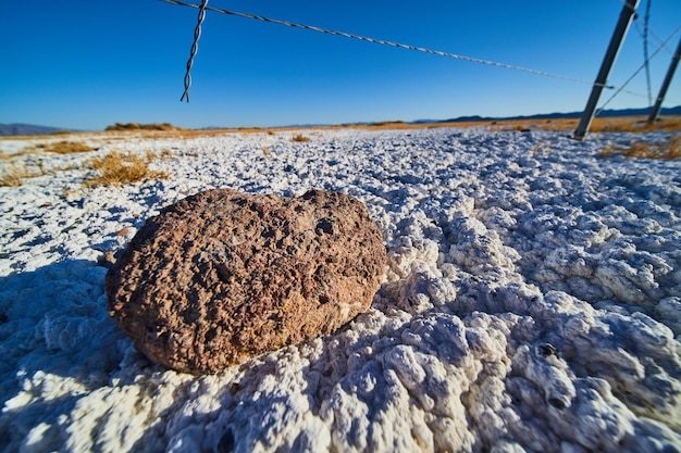 Detail eines kleinen Felsens auf einer ungewöhnlichen Wüstenlandschaft mit weißem Sand