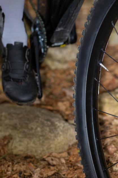 Foto detail eines mountainbike-reifens mit einer leicht schlammigen seitenwand, der auf einer felsigen oberfläche steht