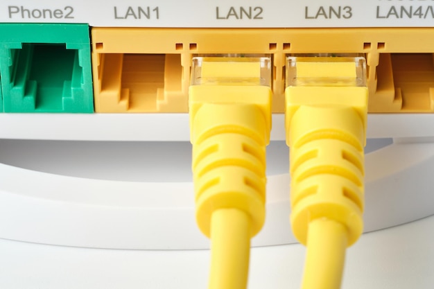 Detail von zwei gelben RJ45-Ethernet-Kabeln, die in einem Router in Lan2- und Lan3-Verbindungen verbunden sind