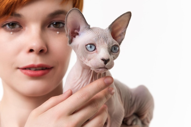 Detailansicht auf Sphynx Hairless Cat in den Händen der jungen Frau Studioaufnahme auf weißem Hintergrund