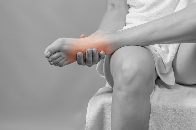 Detailansicht des Fußes in weiblichen Händen Weibliche Beine Reflexzonenmassage Selbstmassage der Füße