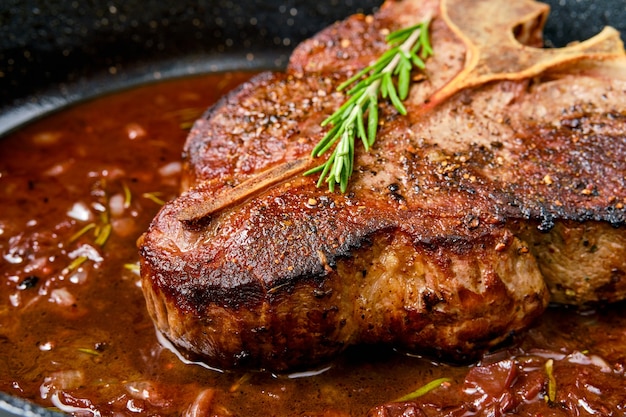 Detailansicht des Porterhouse-Steaks in Weinsauce in der Pfanne