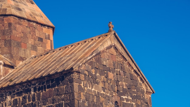 Detailansicht einer alten Sevanavank-Kirche in Sevan Blauer Himmel und helle Herbstfarben am sonnigen Tag Antiker Tempel Stock Fotografie