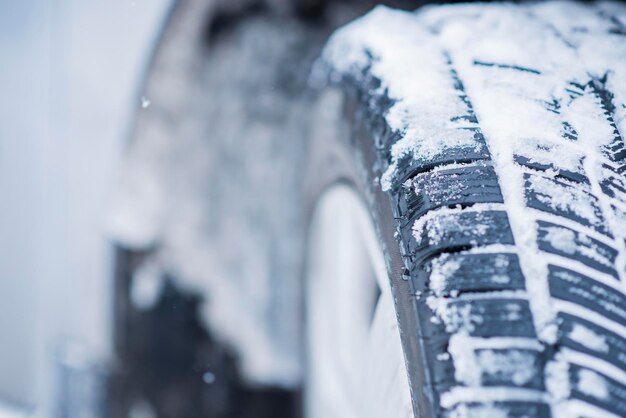 Detailansicht von Winterreifen auf einer schneebedeckten Straße in kalten Wintermonaten.