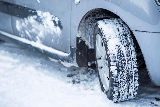 Detailansicht von Winterreifen auf einer schneebedeckten Straße in kalten Wintermonaten.