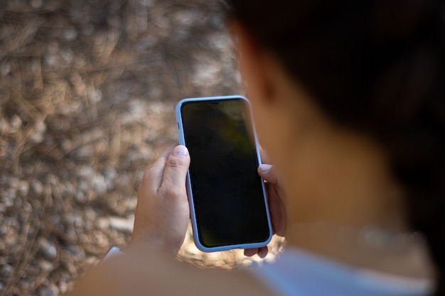 Detailnahaufnahme des jungen sportlichen Mädchens, das das Mobile benutzt