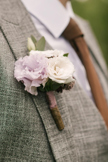 Details der Anzugblumen-Boutonniere-Nahaufnahme der Männer des Bräutigams