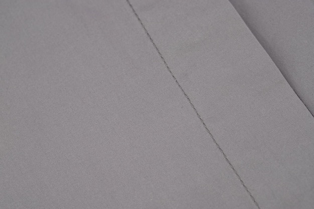 Details der Verschlüsse und Nähte eines Damenhemdes aus grauem Baumwollstoff