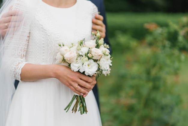 Details des Hochzeitsmorgens Hochzeitsblumenstrauß in den Händen der Braut