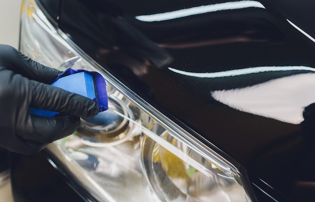 Foto detalhamento do carro homem aplica nano revestimento protetor no carro foco seletivo