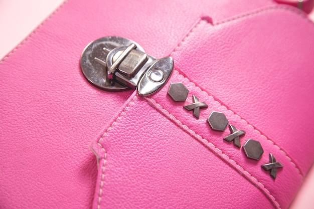 Detalhe da bolsa de couro rosa em fundo rosa.