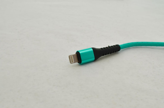 Detalhe da conexão do cabo USB da Apple destacado em uma superfície clara perfeita para conceitos de tecnologia moderna Cabo que oferece velocidade e transferência de dados