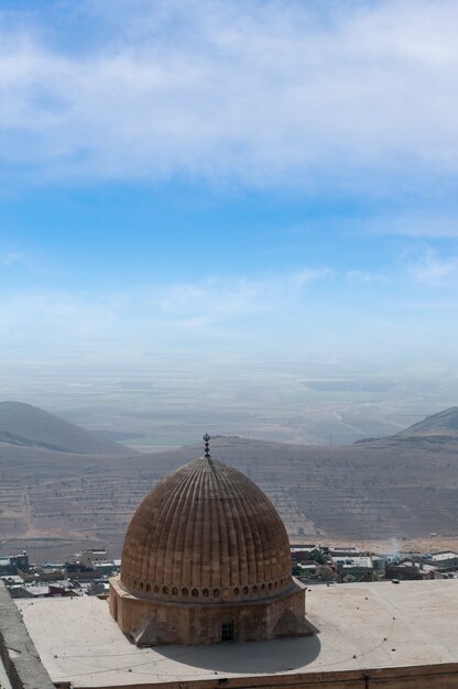 Detalhe da cúpula de uma mesquita da cidade de Mardin, na Turquia, com fundo da Mesopotâmia.