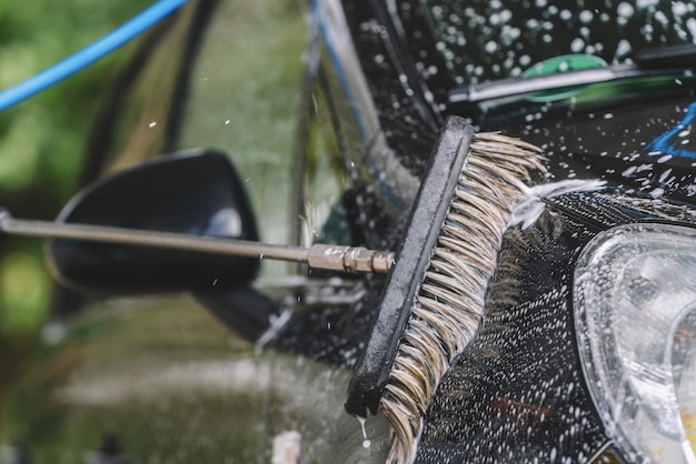 Detalhe da escova de limpeza no carro no lava-jato