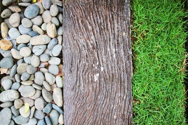 Detalhe da textura de projeto do gaden com cascalho branco, madeira velha e decoração da grama na terra no jardim.