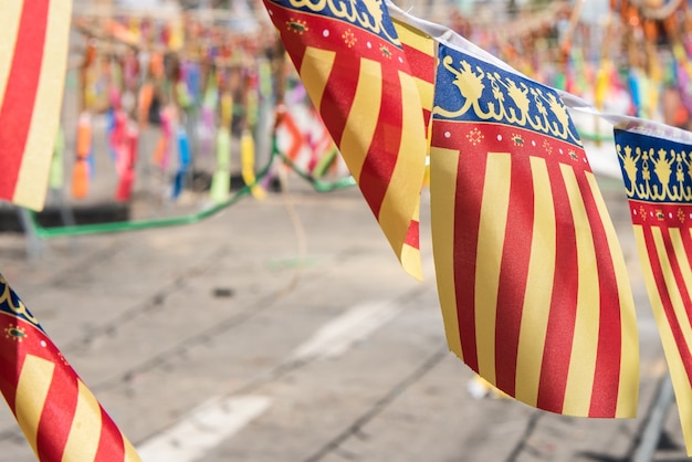 Detalhe das bandeiras da Comunidade Valenciana junto a fogos de artifício.