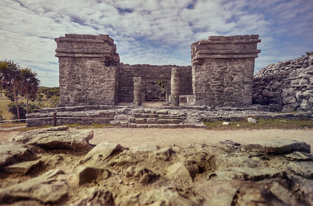 Detalhe das colunas e todas as construções de um templo maia do complexo de tulum, no méxico.