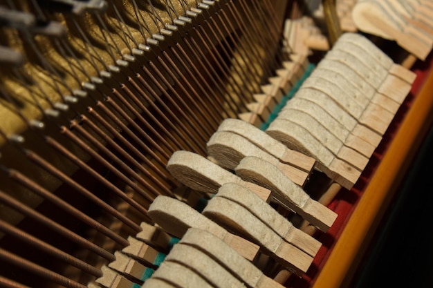 Detalhe das partes internas de um piano ou piano de cauda Foco seletivo Detalhes do interior do instrumento musical Martelos e cordas dentro de um piano Parte do mecanismo interno