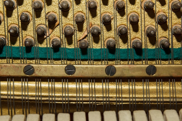 Detalhe das partes internas de um piano ou piano de cauda Foco seletivo Detalhes do interior do instrumento musical Martelos e cordas dentro de um piano Parte do mecanismo interno