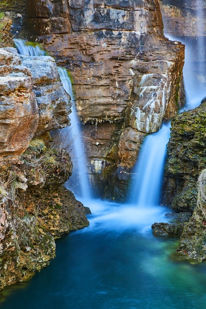 Foto detalhe de duas cachoeiras despejando em um rio através de falésias rochosas