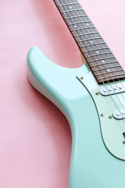 Foto detalhe de guitarra elétrica em uma superfície rosa