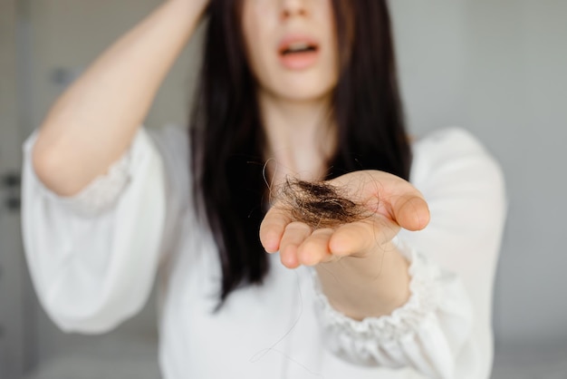 Foto detalhe de mulher preocupada segurando queda de cabelo