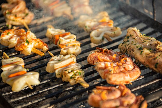 Detalhe de saborosos espetos de peixe na grelha com fumaça