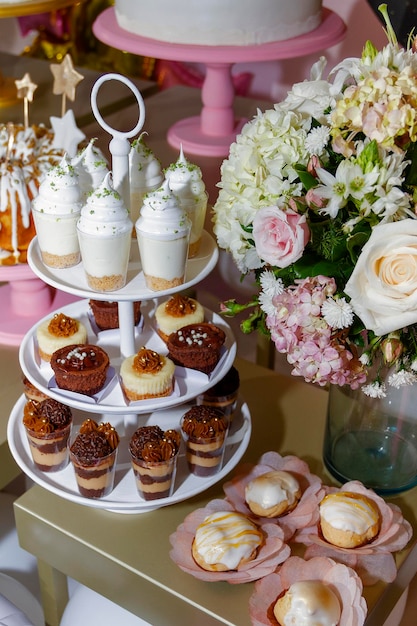 Detalhe de sobremesas e decoração floral de mesas para celebrações