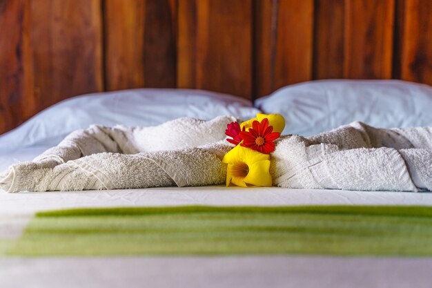 Detalhe de toalhas brancas na cama em um quarto de hotel na montanha com decoração acima.