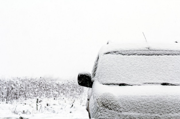 Detalhe de um carro na rua durante a queda de neve no inverno