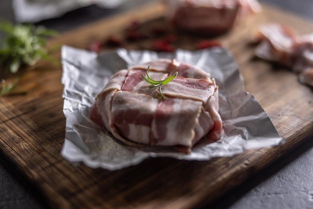 Detalhe de um envoltório de queijo e bacon pronto para fritar colocado em uma tábua de cortar