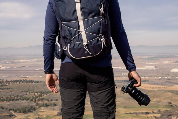 Detalhe de um fotógrafo irreconhecível segurando a câmera com a mão em primeiro plano