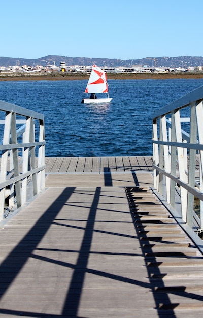 Detalhe de um ponto da ponte da passagem de ancoragem e no meio um barco de navigação pequeno.