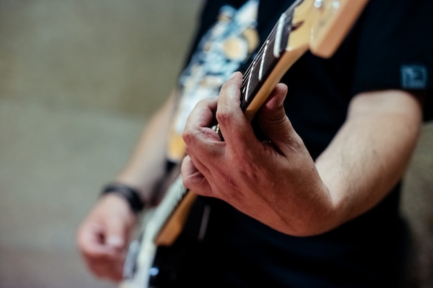 Detalhe de um roqueiro tocando guitarra elétrica