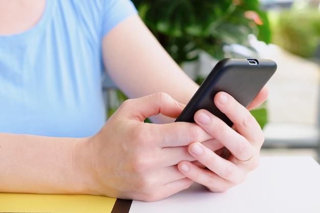 Detalhe de um smartphone em mãos femininas Mulher usando smartphone