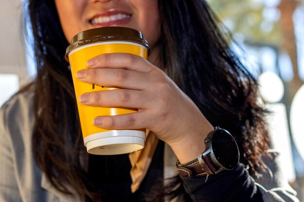 Detalhe de uma garota de negócios com smartwatch bebendo café