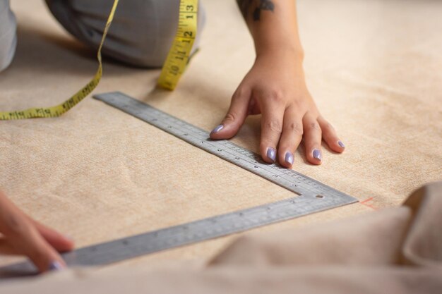 Foto detalhe de uma pessoa medindo tecido usando réguas