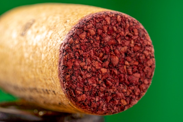 Foto detalhe de uma rolha de cortiça usada numa garrafa de vinho tinto com uma marca de rubi absorvida no contacto