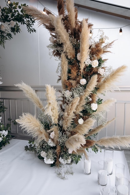 Detalhe do arco de casamento em um banquete no estilo boho Plantas vivas e luz decorativa