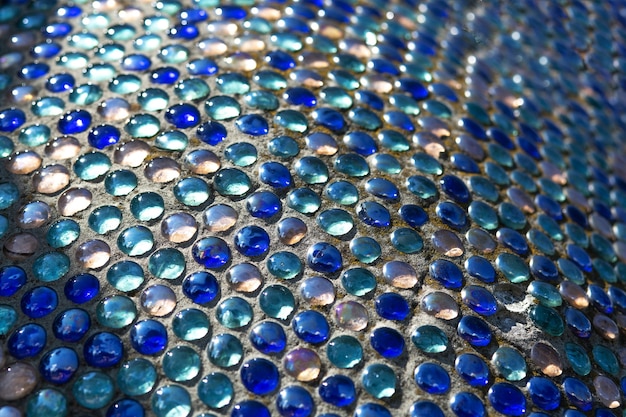 Detalhe do mosaico de vidro abstrato azul na rua com a luz do sol. foco seletivo