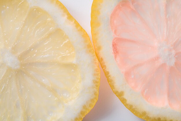 Detalhe macro de fatias de limão amarelo e rosa em fundo branco Frutas cítricas multicoloridas