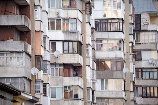 Detalhes arquitetônicos da antiga fachada de prédio de apartamentos com muitas janelas e varandas